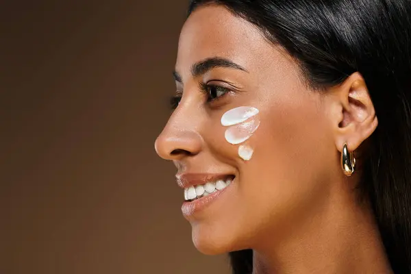 Beautiful woman applies skincare products, celebrating diversity in beauty and self-care. — Stock Photo