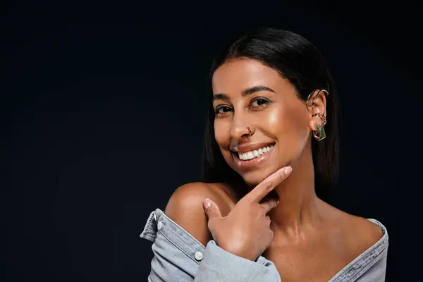 Donna sorridente mette in mostra i suoi gioielli e sorride in uno studio. — Foto stock