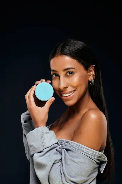 African American woman with brunette hair promotes skincare in a studio setting. — Stock Photo