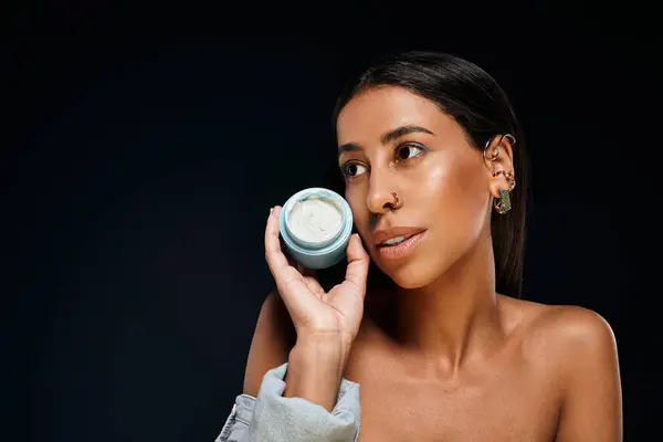African American woman with brunette hair highlights skin care routine while posing in studio. — Stock Photo