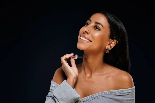 A confident African American woman with brunette hair enhances her skincare routine in a studio. — Stock Photo