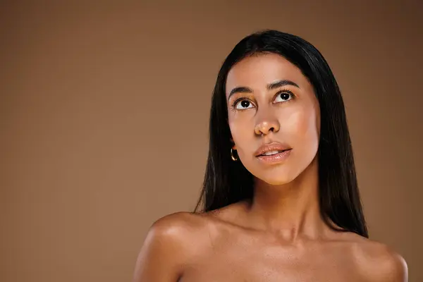 A stunning African American woman highlights skincare and beauty in a studio setting. — Stock Photo