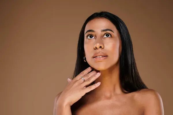 African American woman with brunette hair showcases her beauty in a studio. — Stock Photo