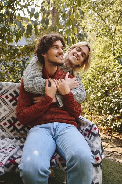 In a peaceful outdoor space, a young couple shares laughter and warmth. The beautiful surroundings enhance their connection as they embrace affectionately, radiating joy. — Stock Photo