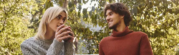 Two handsome young men share a moment of connection, enjoying each others company amidst vibrant greenery. — Stock Photo