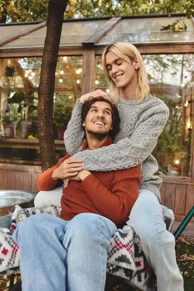 In a serene garden cabin, Young loving gay couple share a joyful moment. — Stock Photo
