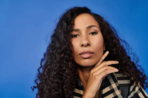 A confident woman with beautiful curls poses, showcasing her natural beauty and grace. — Stock Photo