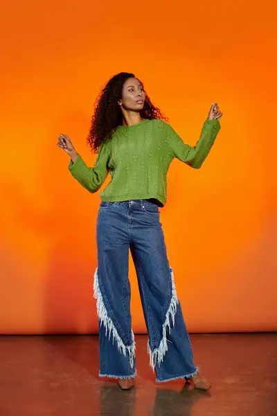 A stylish woman expresses joy through movement in a colorful setting showcasing her fashion. — Stock Photo