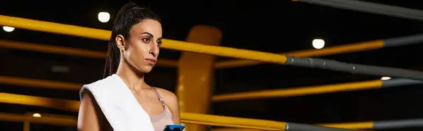Woman stands ready with towel and phone, focused on the upcoming exercise session ahead. — Stock Photo