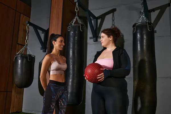 Women collaborate in exercise, sharing tips and motivation during a workout session at the gym — Stock Photo