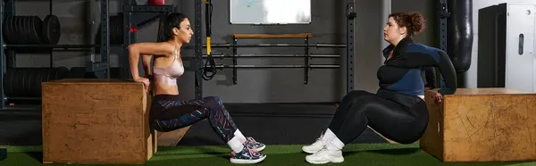 Two women perform workout routines together, enhancing fitness and motivation in a gym. — Stock Photo
