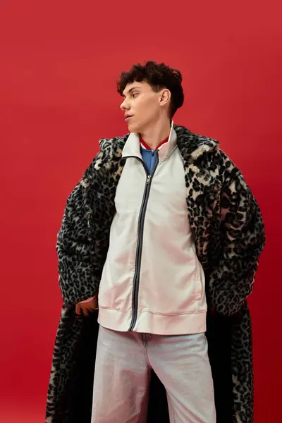 Handsome man showcases his fashion sense in a chic leopard coat with casual attire, exuding charm. — Stock Photo