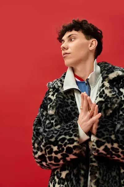 Handsome man showcases bold fashion choices with a dynamic pose against a bright red wall — Stock Photo