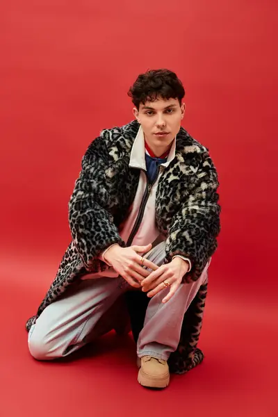 Handsome man kneels on the ground, showcasing his stylish ensemble and unique fashion sense. — Stock Photo