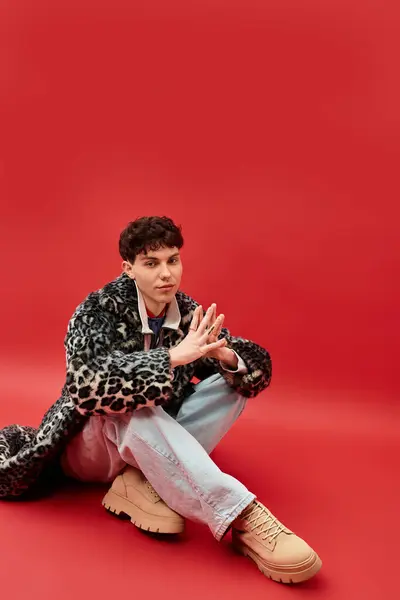 Handsome man poses thoughtfully, showcasing unique fashion against a vibrant background. — Stock Photo