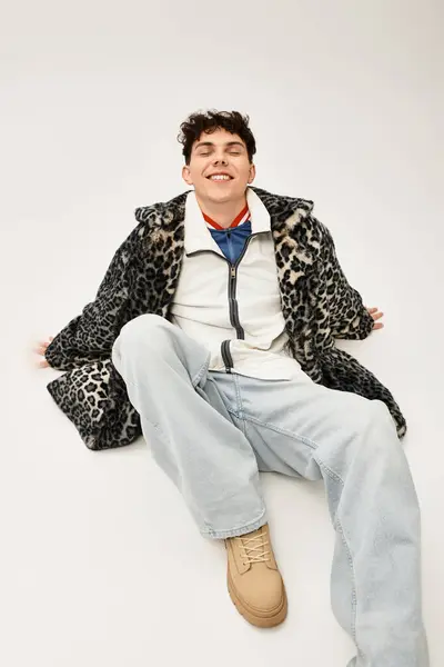 A joyful man in a trendy outfit sits comfortably, showcasing his casual style. — Stock Photo