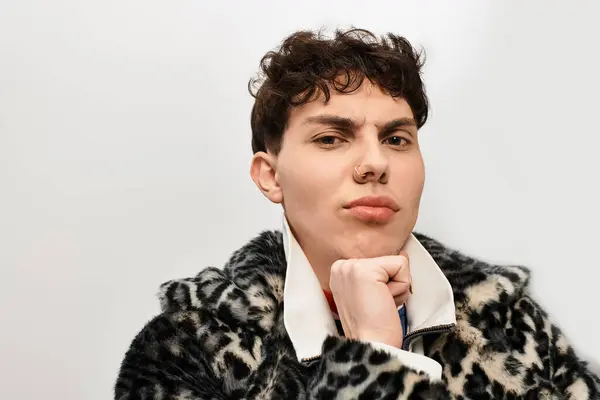 Красивий чоловік позує вдумливо, виділяючи свій унікальний стиль в сучасному середовищі. — стокове фото