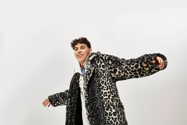 Un hombre elegante posa alegremente en un abrigo de estampado de leopardo de moda en un entorno moderno. — Stock Photo