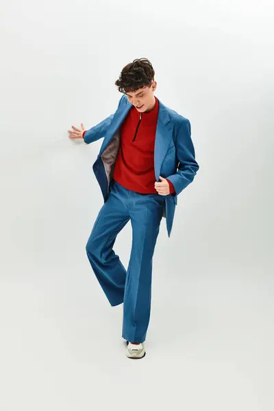 Красивый мужчина в ярком костюме и стильной рубашке уверенно позирует в светлом пространстве. — стоковое фото