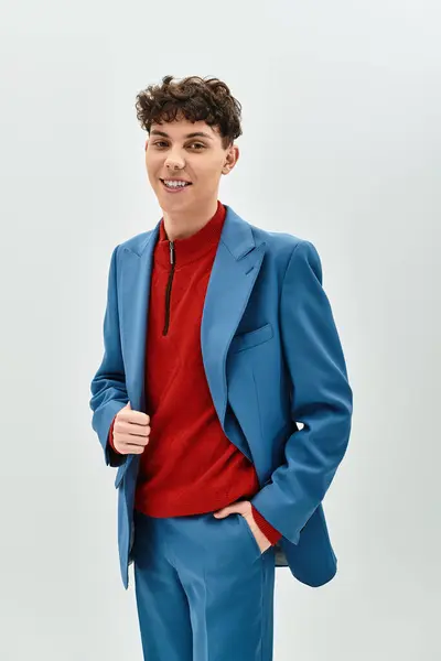 A handsome man in a blue suit and red sweater stands with a smile, exuding charm and confidence. — Stock Photo