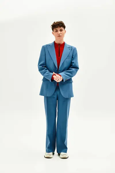 A stylish man models a modern blue suit with bold red accents in studio lighting. — Stock Photo