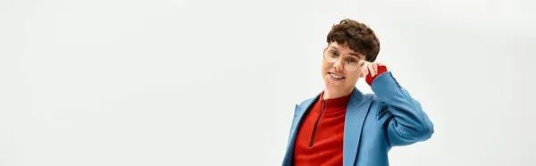 Stylish man with curly hair smiles confidently while posing in a contemporary setting. — Stock Photo
