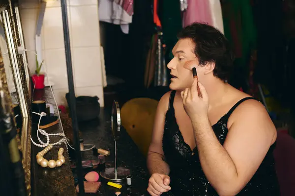 Drag queen applies makeup with focused precision in a colorful dressing room before the show. — Stock Photo