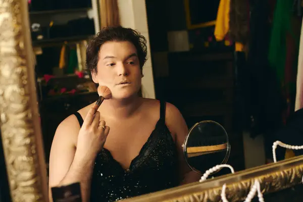 A drag queen applies makeup in a vibrant backstage dressing room for a performance. — Stock Photo