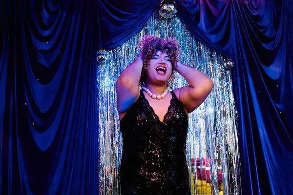 Boldly adorned in striking makeup, the drag queen electrifies the stage and enchants the crowd. — Stock Photo