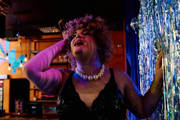 Une drag queen talentueuse électrise la scène avec un maquillage vibrant dans un spectacle de vacances festif. — Photo de stock