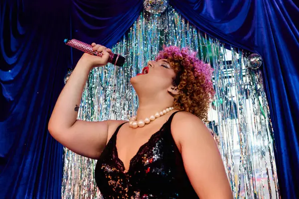 A skilled drag queen dazzles with vibrant makeup and style in a lively on-stage performance. — Stock Photo