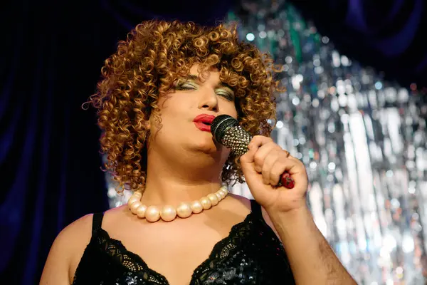 Una talentuosa drag queen brilla sul palco, incantando la folla con un trucco vibrante e carisma. — Foto stock