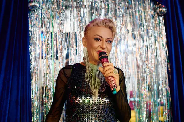 A talented drag queen showcases extravagant makeup and engages the crowd during a festive show. — Stock Photo