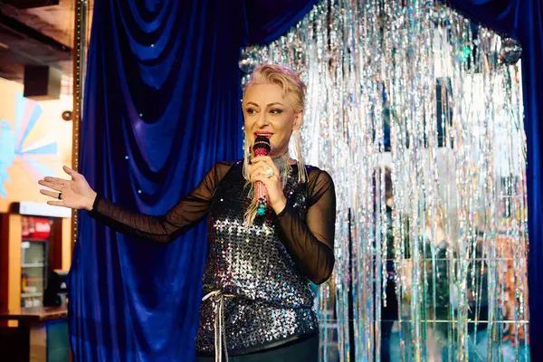 Androgynous drag performer dazzles in extravagant makeup, bringing joy on stage at a holiday show. — Stock Photo