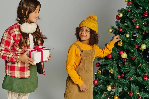 Dos niños llenos de emoción, preparando un árbol de Navidad y compartiendo alegría festiva juntos. - foto de stock