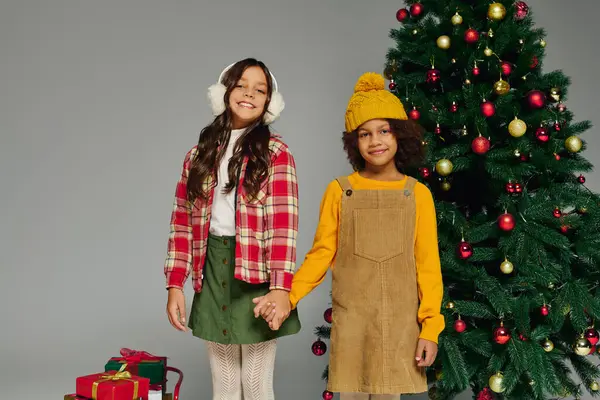 Two joyful kids celebrate Christmas with vibrant gifts and decorations all around. — Fotografia de Stock