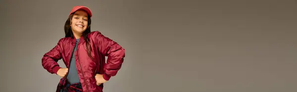 Girl in vibrant red jacket and cap embodies holiday spirit with a bright smile in December 2025 — Stock Photo