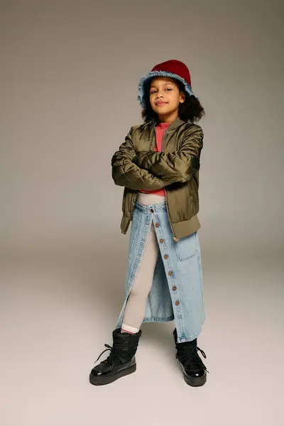 Young girl confidently showcases festive style in a cozy setting, symbolizing Christmas cheer. — Stock Photo