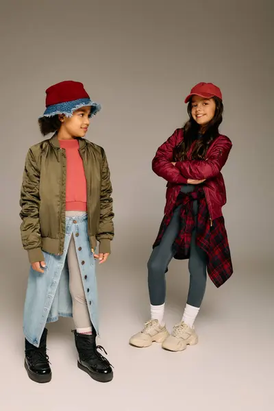 Due bambine presentano abiti di Natale alla moda, pronte a festeggiare la festa con stile. — Foto stock