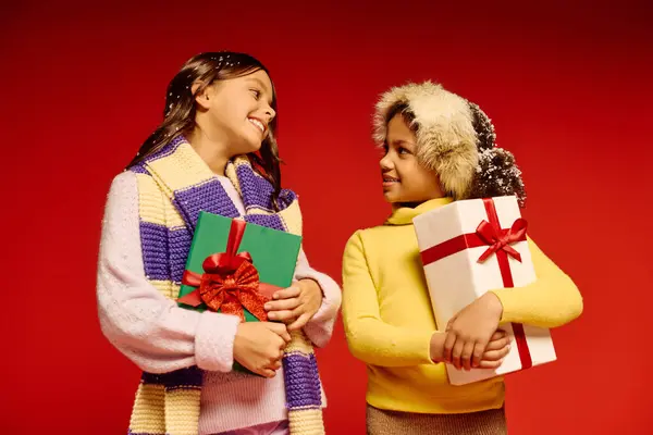 Two joyful girls share smiles and holiday gifts, embodying the spirit of Christmas 2025. — Stock Photo