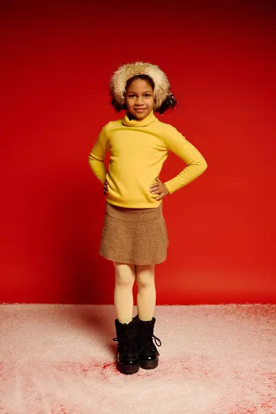 Joyful girl dressed warmly poses with a radiant smile in a festive setting for Christmas joy. — Stock Photo