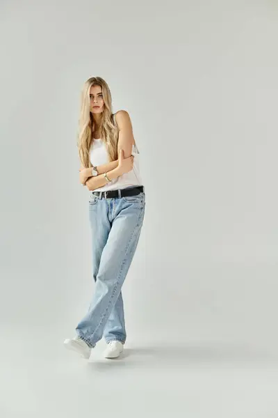 Blonde young woman showcases casual beauty in a stylish studio atmosphere with confidence. — Stock Photo