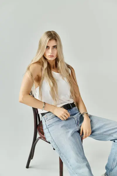 Long blonde hair cascades over shoulders of a young woman as she poses confidently in casual attire. — Stock Photo