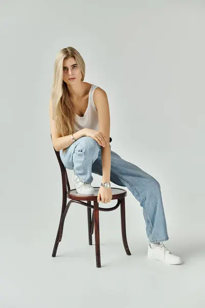 A young woman with long blonde hair showcases her beauty in a stylish studio setting. — Stock Photo