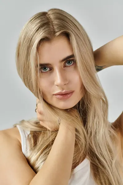 Ein stilvolles Studio zeigt eine junge Frau mit atemberaubenden blonden Haaren, die Mode präsentiert. — Stockfoto