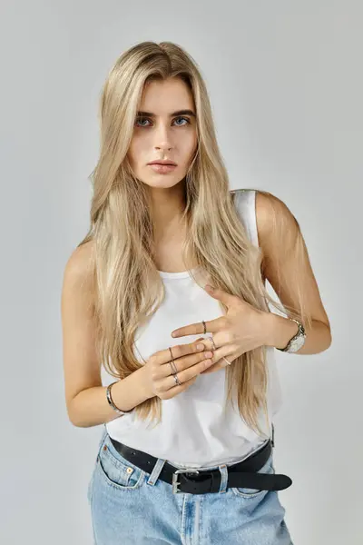 This striking young woman with long blonde hair poses gracefully in a vibrant studio setting. — Stock Photo