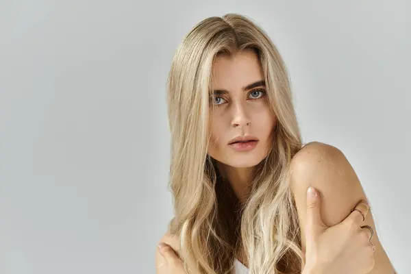 A beautiful young woman poses in a studio, highlighting her fashion sense and natural beauty. — Stock Photo