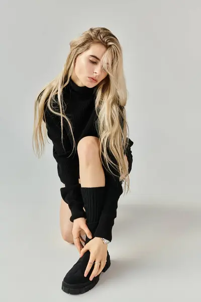 Young woman showcases her fashion sense and beauty in a minimalist studio, exuding confidence. — Stock Photo