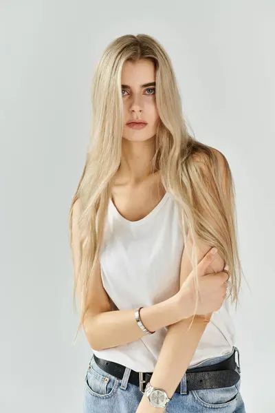 Eine schöne junge Frau mit langen blonden Haaren posiert elegant in einem Studio und strahlt Stil aus. — Stockfoto