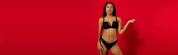 A beautiful young Black woman poses confidently in stylish underwear against a vibrant backdrop, banner — Stock Photo